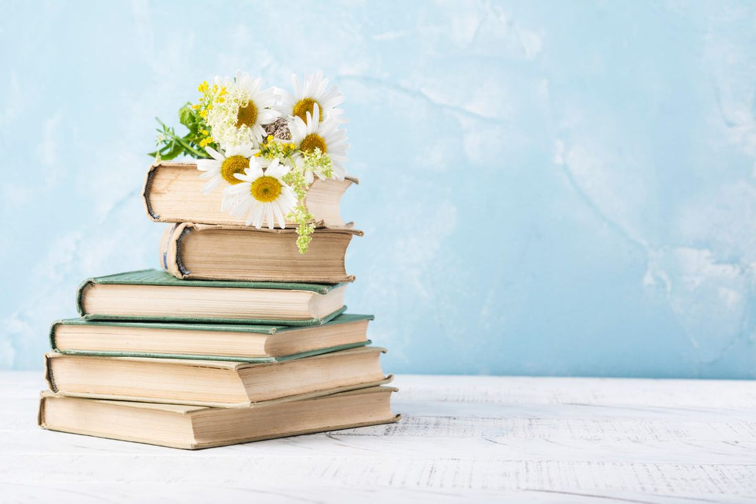 Image of a stack of books on a table with a pale blue background - Literary Gifts UK