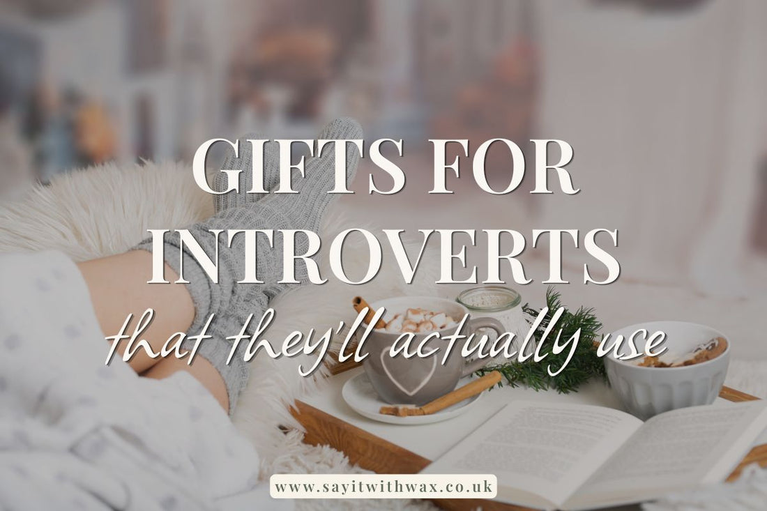 Gifts for introverts headline over a cosy desk with candle, open book and warm snack in a soft-lit setting.