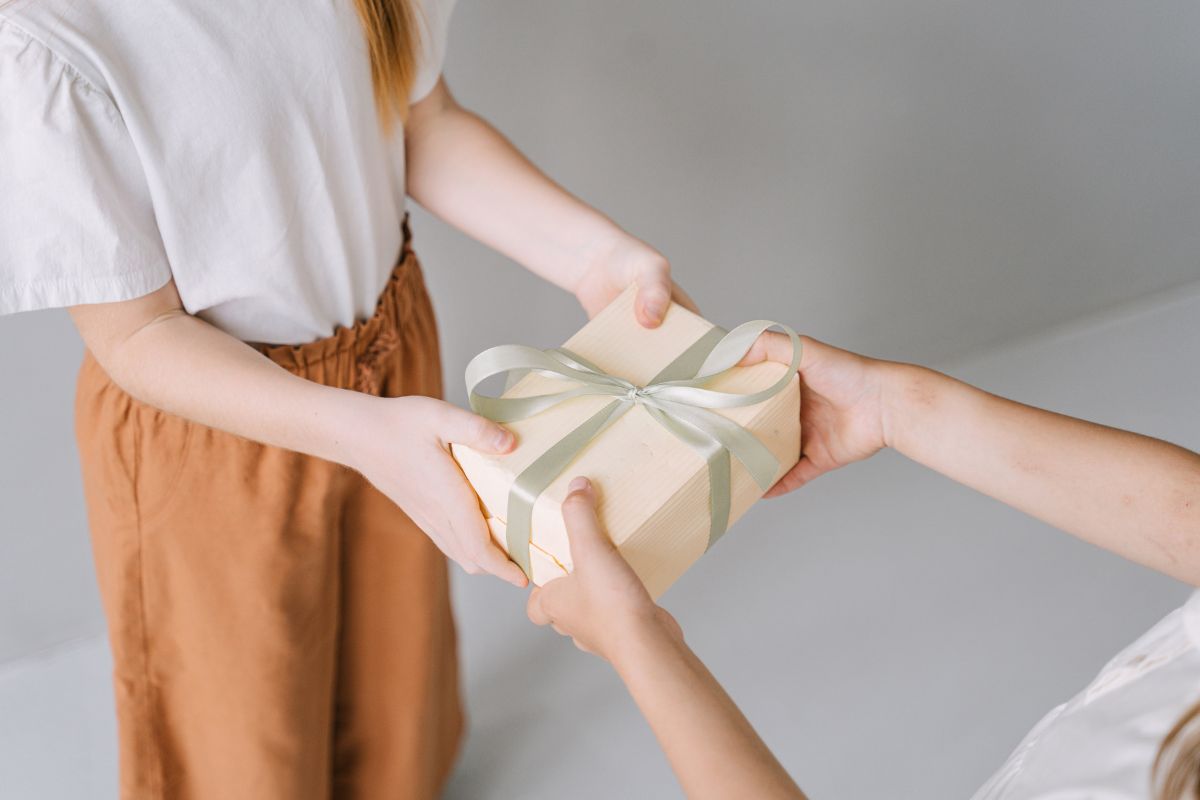 Woman receiving a neatly wrapped gift box, representing a thoughtful luxury candle gift set for her.