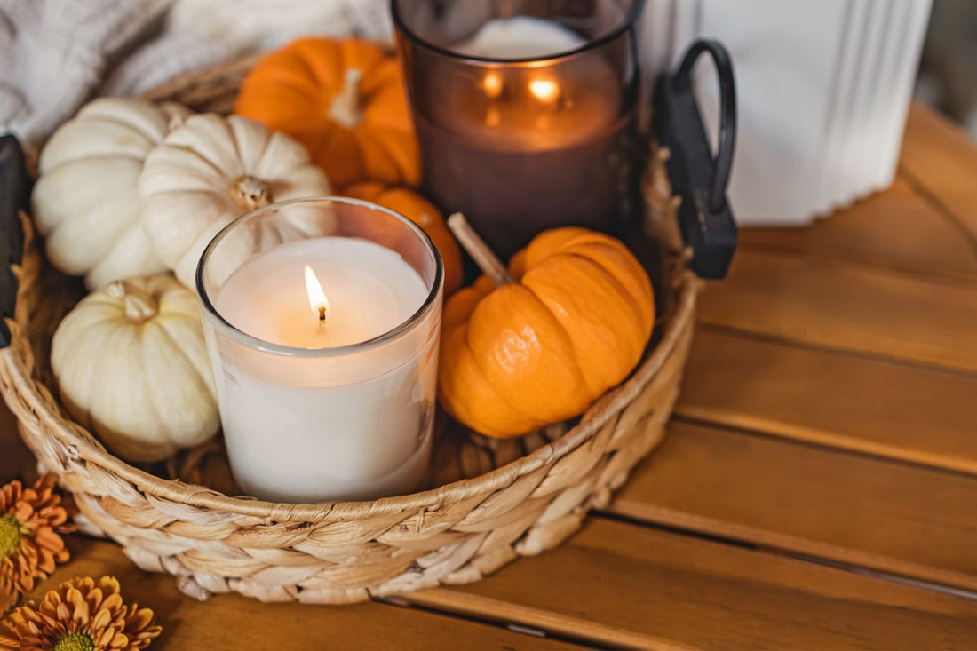 tray with lit clear glass candle surrounded by little munchkin pumpkins for blog post Halloween candles gifts for book lovers.