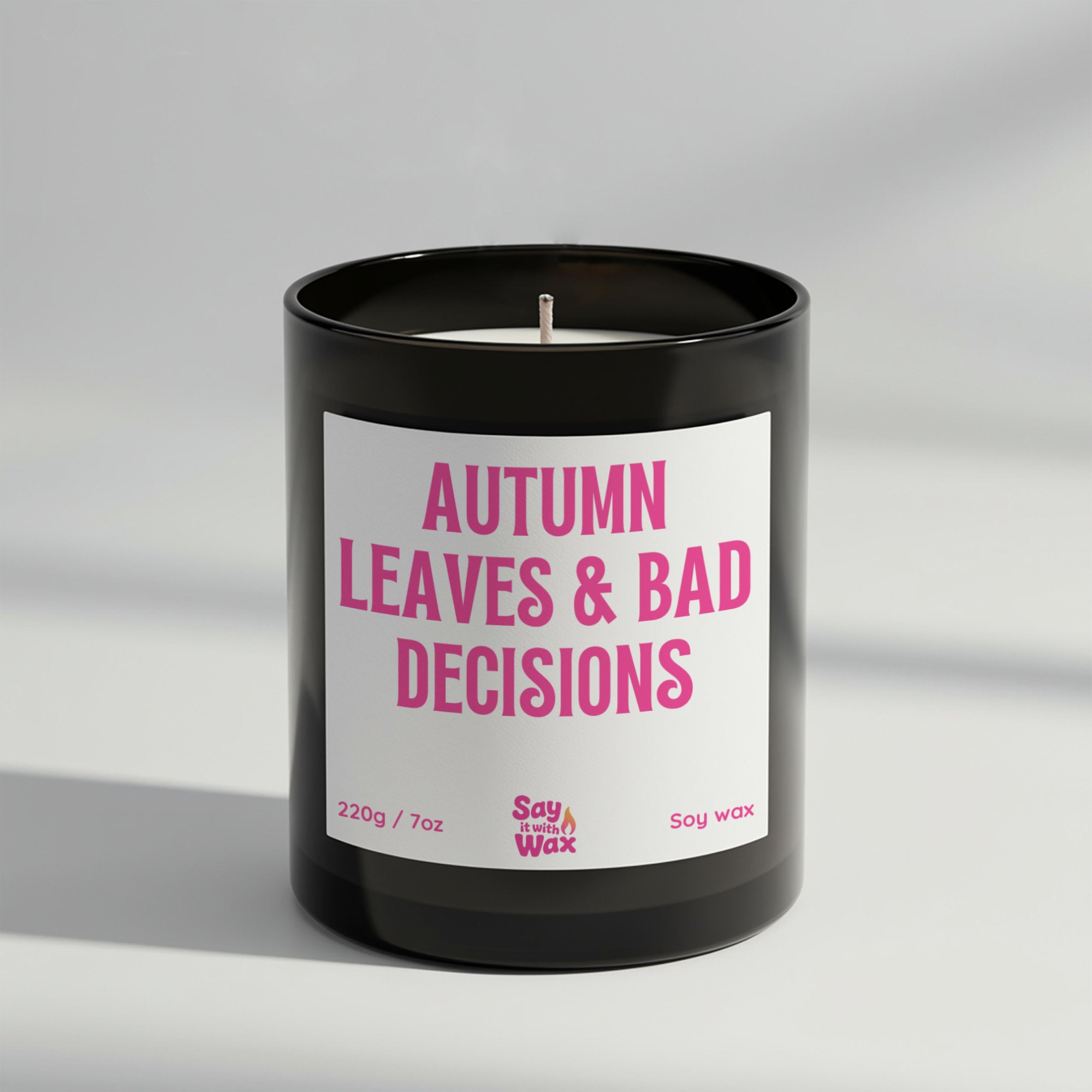 Autumn Leaves & Bad Decisions soy wax candle in matte black glass jar with seasonal label and ash wooden lid, scented with spicy Sahara fragrance