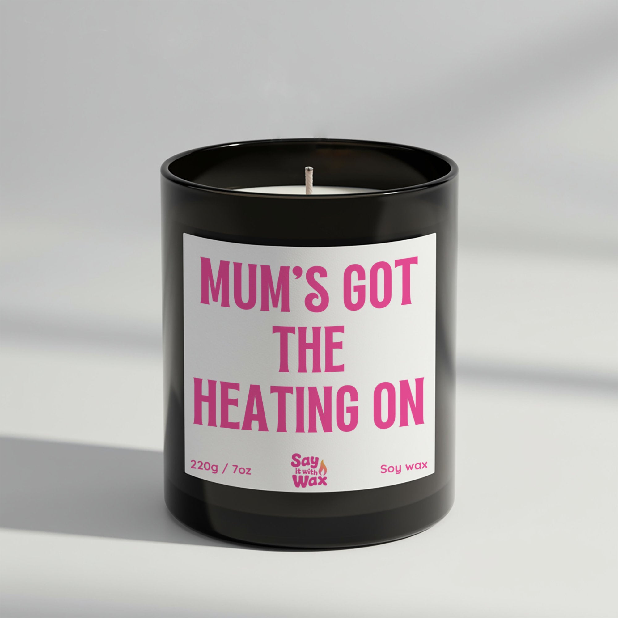 Mum’s Got the Heating On soy wax candle in matte black glass jar with seasonal label and ash wooden lid, scented with cosy Fireside fragrance