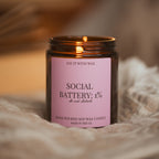 Lit Social Battery: 1% candle nestled in soft draped fabric, warm blurred background.